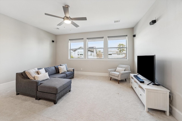 living room with light colored carpet, visible vents, ceiling fan, and baseboards