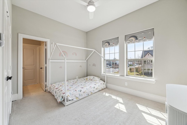 carpeted bedroom with baseboards and a ceiling fan