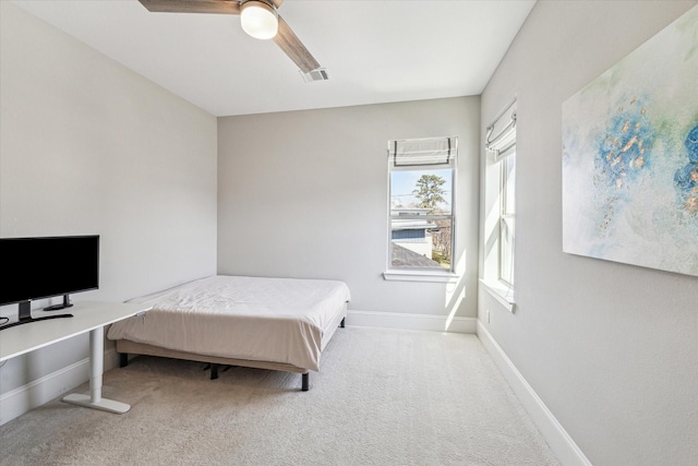 carpeted bedroom featuring a ceiling fan, visible vents, and baseboards