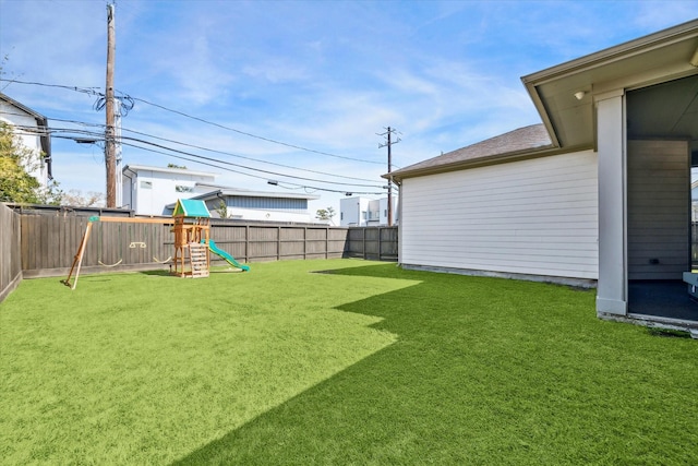 view of yard with a fenced backyard and a playground