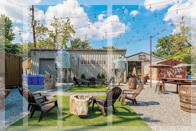 view of play area with an outdoor fire pit, a lawn, and an outdoor structure