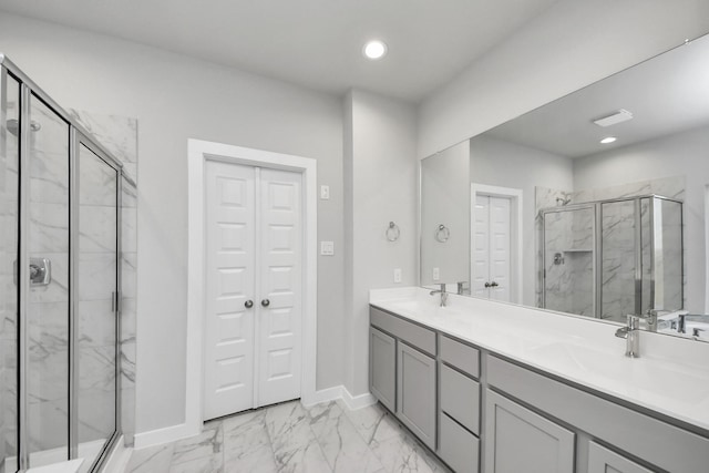 full bathroom with marble finish floor, a sink, a marble finish shower, a closet, and double vanity