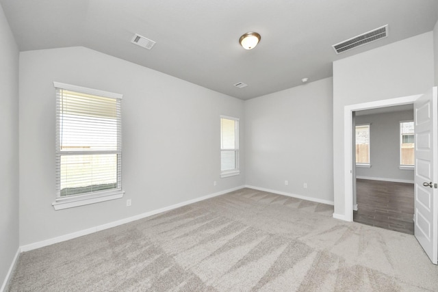 unfurnished room with visible vents, plenty of natural light, and carpet flooring