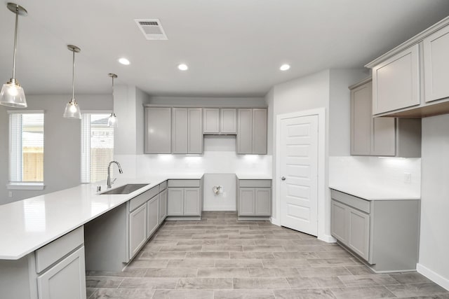 kitchen featuring visible vents, gray cabinets, and a sink