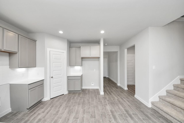 kitchen with recessed lighting, gray cabinetry, light wood-type flooring, and baseboards