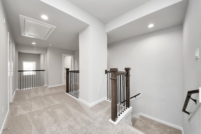 corridor with an upstairs landing, recessed lighting, carpet flooring, baseboards, and attic access