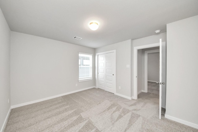 unfurnished bedroom with carpet, visible vents, a closet, and baseboards