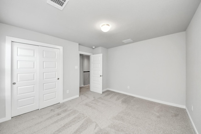 unfurnished bedroom with visible vents, baseboards, a closet, and carpet flooring