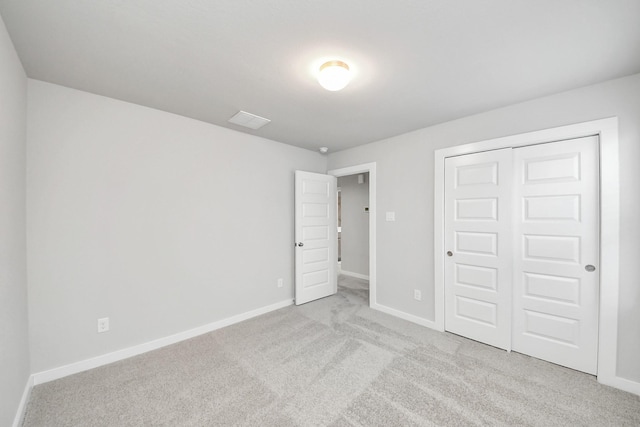 unfurnished bedroom featuring a closet, visible vents, baseboards, and carpet floors