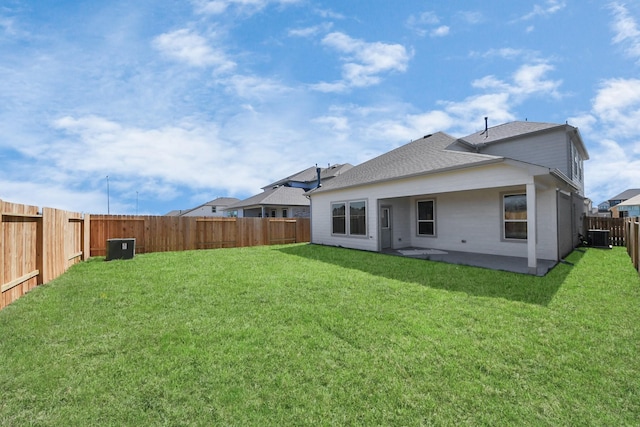 back of property featuring central AC, a fenced backyard, a yard, a shingled roof, and a patio area