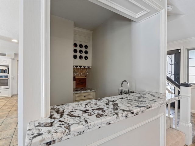 bar with crown molding, backsplash, wall oven, light tile patterned flooring, and oven