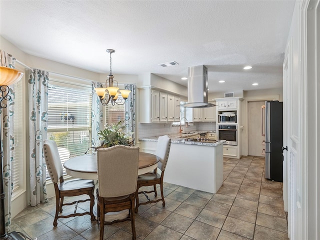 dining area featuring a textured ceiling, recessed lighting, visible vents, and a notable chandelier