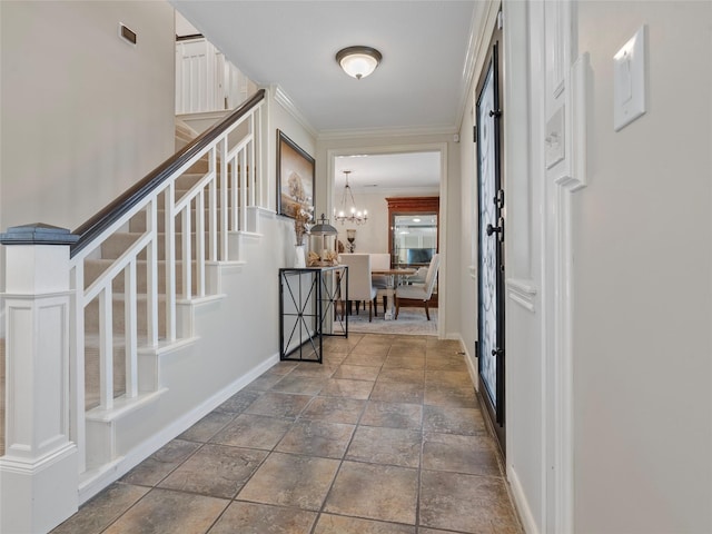 entryway featuring a chandelier, visible vents, baseboards, ornamental molding, and stairway