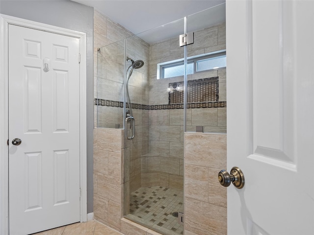 bathroom with tile patterned flooring and a shower stall