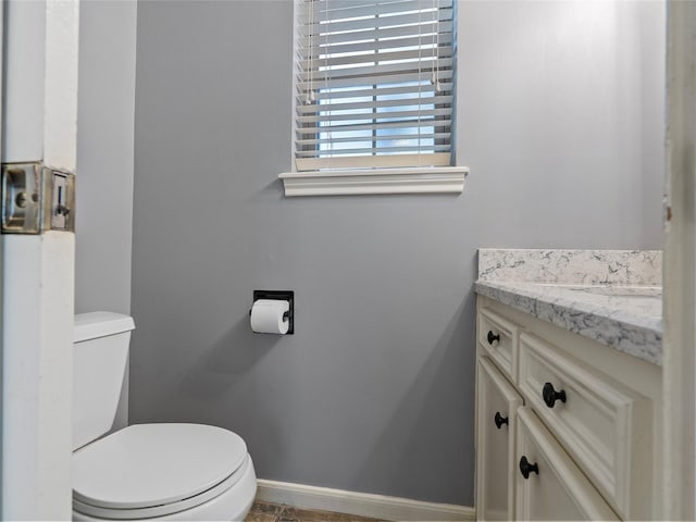 bathroom featuring vanity, toilet, and baseboards