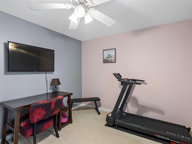 workout room with baseboards, a ceiling fan, and light colored carpet