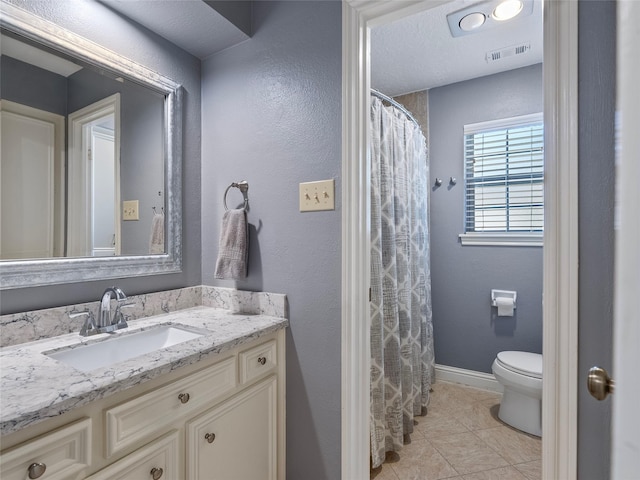 bathroom featuring visible vents, baseboards, toilet, tile patterned flooring, and vanity