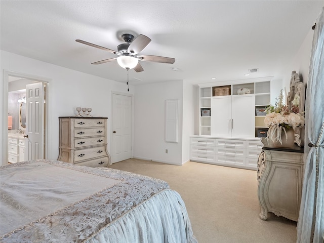 bedroom with connected bathroom, a ceiling fan, and light colored carpet