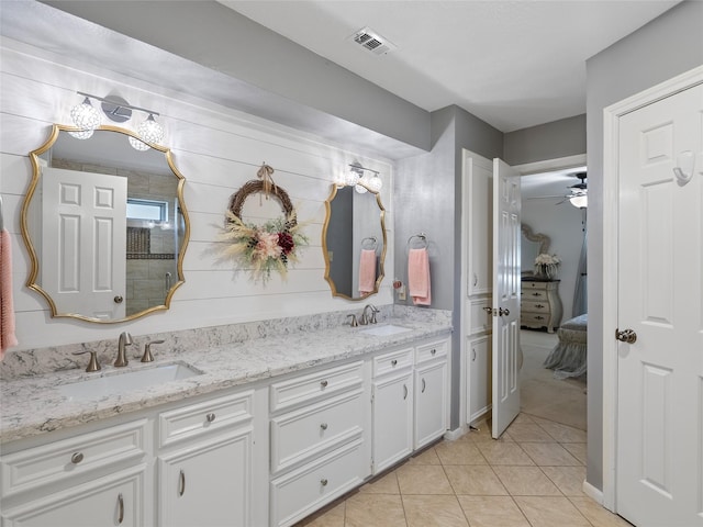 bathroom featuring tile patterned flooring, a sink, ensuite bath, and double vanity