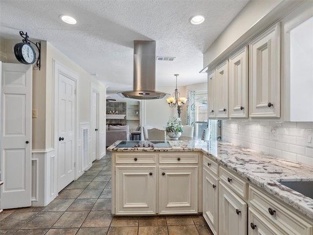 kitchen featuring black electric cooktop, island range hood, a peninsula, visible vents, and backsplash