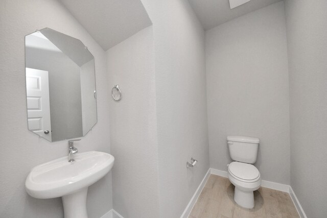 14811 Surfbird Ln, Houston, TX 77049 - bathroom with toilet, wood finished floors, baseboards, and a sink