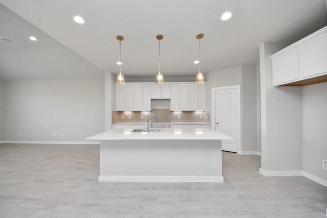 14811 Surfbird Ln, Houston, TX 77049 - kitchen with a sink, light countertops, decorative backsplash, white cabinetry, and a kitchen island with sink