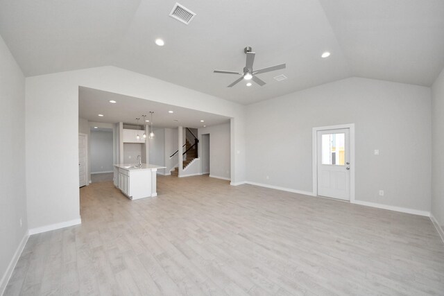 14811 Surfbird Ln, Houston, TX 77049 - unfurnished living room with a sink, visible vents, lofted ceiling, and light wood finished floors