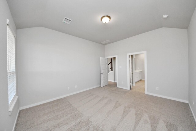 14811 Surfbird Ln, Houston, TX 77049 - unfurnished bedroom with lofted ceiling, light colored carpet, baseboards, and connected bathroom