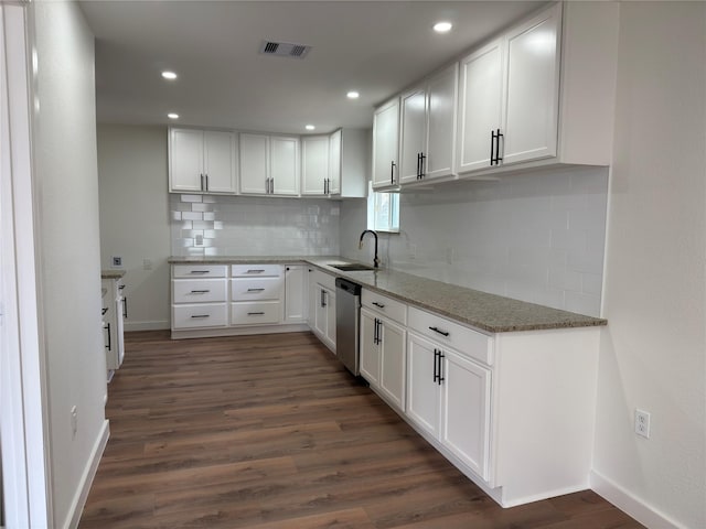 kitchen with light stone counters, dark wood-style floors, visible vents, stainless steel dishwasher, and white cabinets