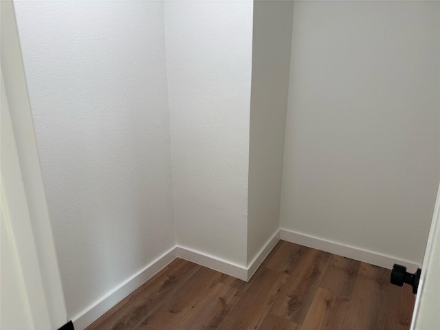 interior space with baseboards and dark wood-style flooring