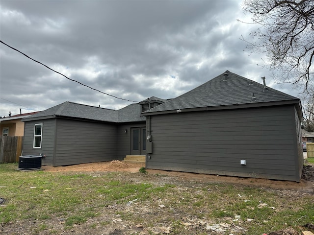 view of property exterior featuring entry steps, fence, cooling unit, and roof with shingles