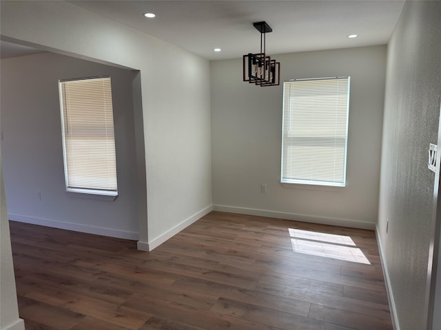 empty room featuring recessed lighting, wood finished floors, and baseboards