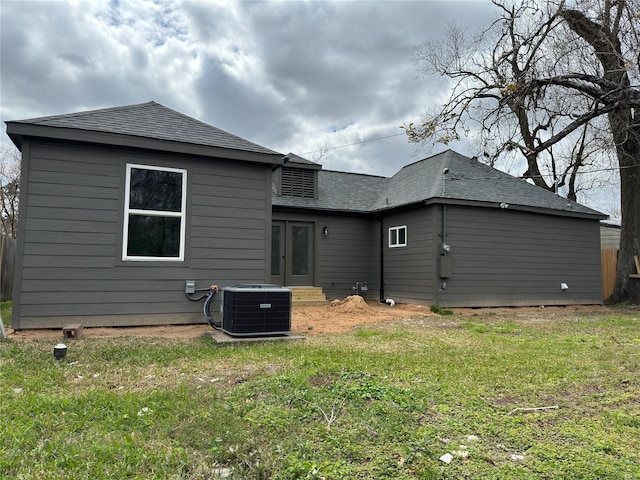 back of house with a shingled roof, a lawn, central AC, and french doors