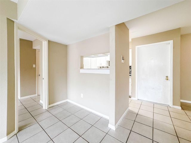 empty room with baseboards and light tile patterned flooring