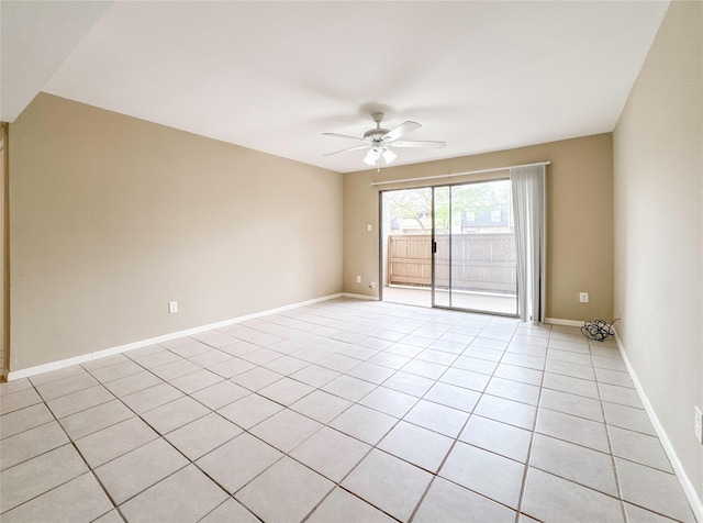 empty room with light tile patterned flooring, a ceiling fan, and baseboards