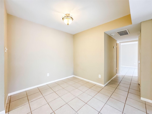 spare room with light tile patterned flooring, visible vents, and baseboards