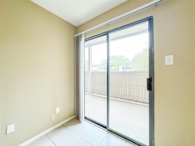 unfurnished room with light tile patterned flooring and baseboards