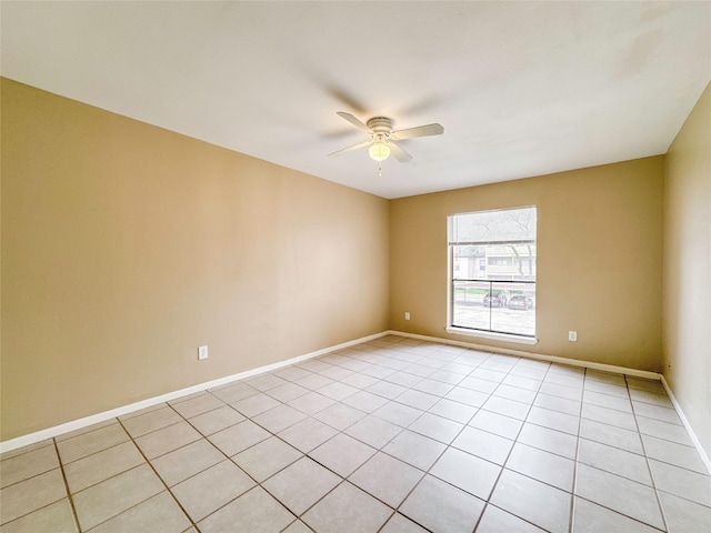 empty room with light tile patterned floors, baseboards, and a ceiling fan