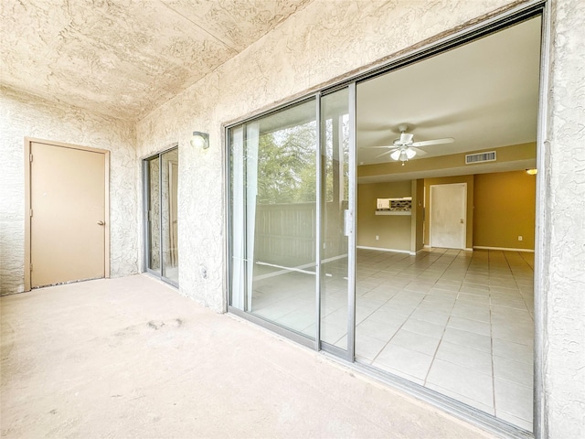 empty room featuring visible vents, a ceiling fan, and tile patterned floors