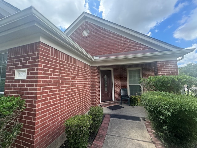 doorway to property featuring brick siding