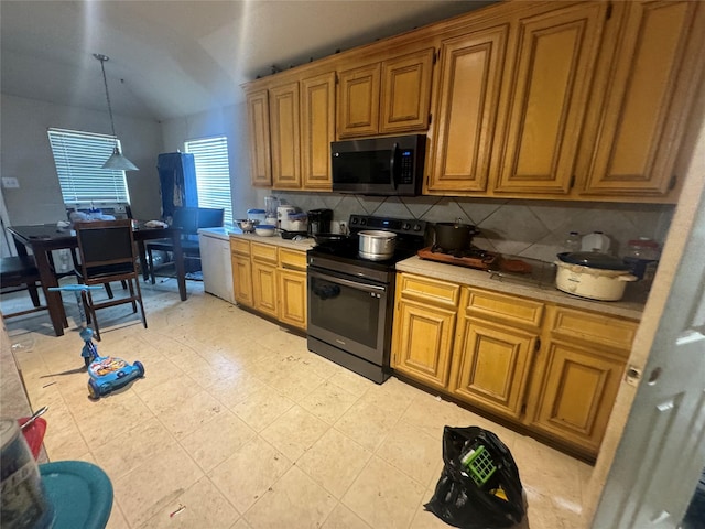 kitchen featuring brown cabinets, tasteful backsplash, light countertops, vaulted ceiling, and stainless steel range with electric stovetop