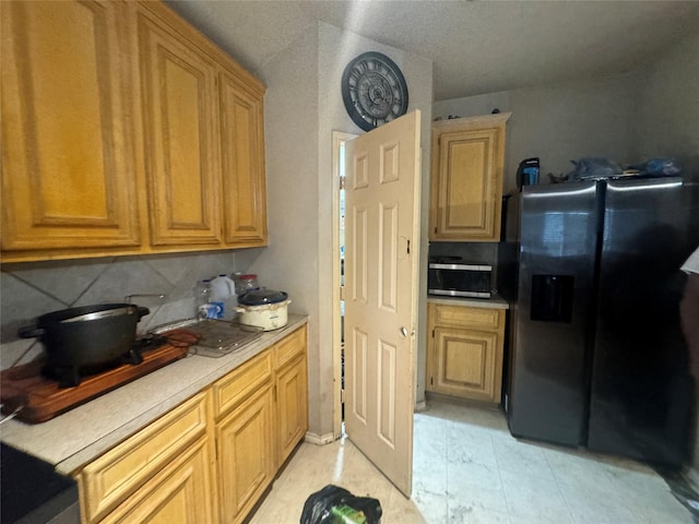 kitchen featuring light countertops, appliances with stainless steel finishes, and decorative backsplash