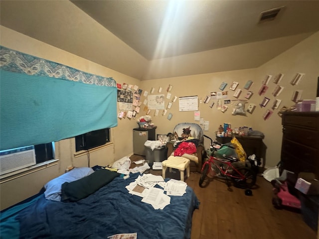 bedroom featuring lofted ceiling, visible vents, cooling unit, and wood finished floors