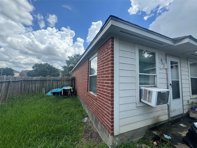 view of property exterior with fence, cooling unit, and brick siding