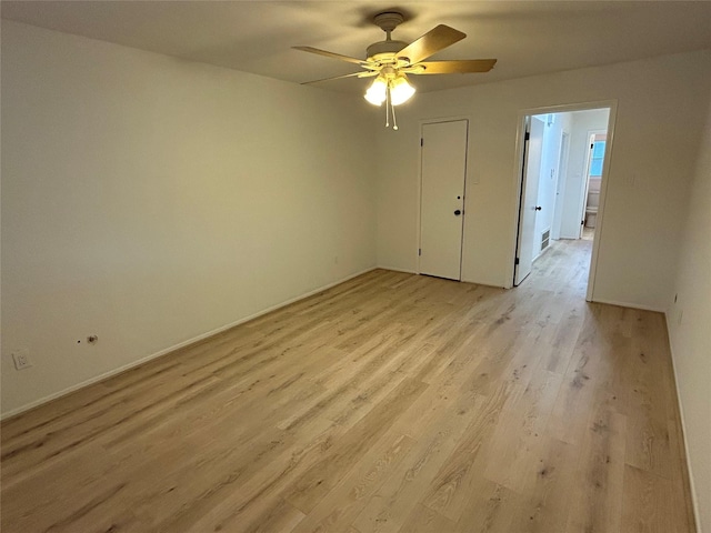 spare room with light wood-type flooring and a ceiling fan