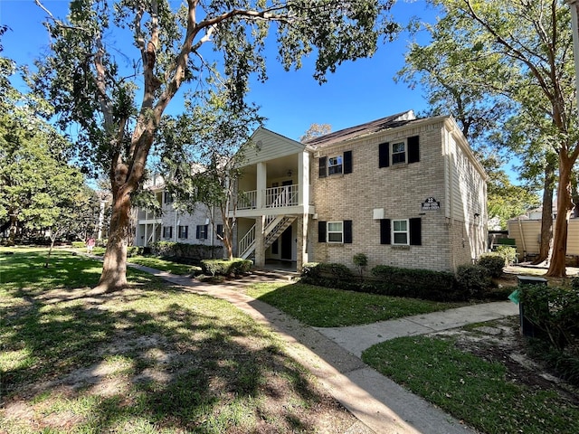 view of front of house featuring a front lawn and brick siding