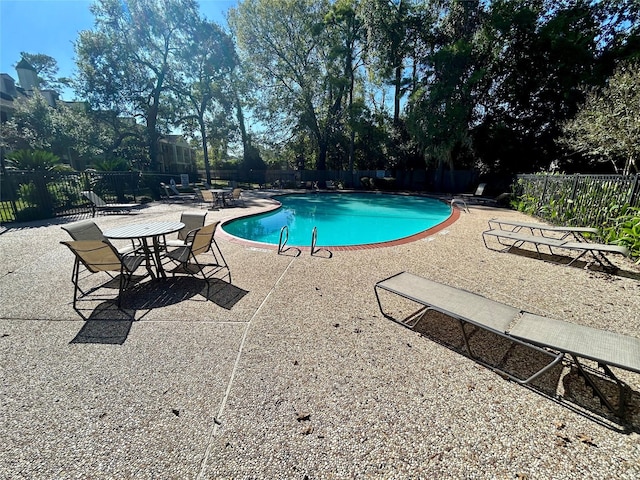 community pool featuring a patio area and fence