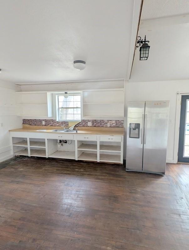 kitchen with dark wood-type flooring, stainless steel fridge, and open shelves