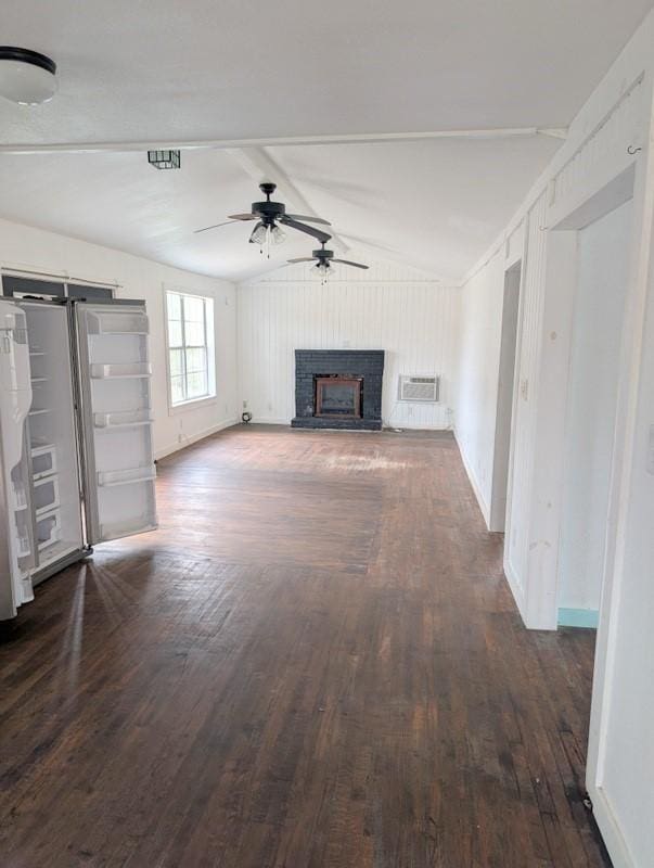 unfurnished living room with baseboards, a fireplace with raised hearth, a ceiling fan, lofted ceiling, and dark wood-type flooring