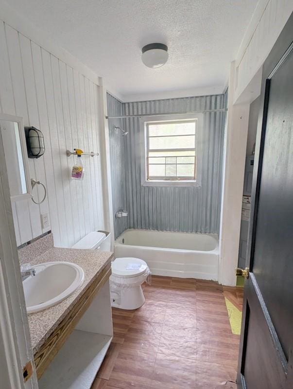 bathroom featuring shower / bath combination, a textured ceiling, toilet, and vanity